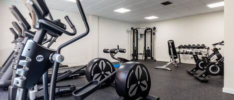 A gym with treadmills, weight machines, and free weights.