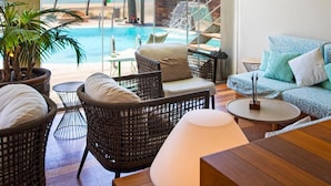 A room with a view of the ocean, a pool, and outdoor seating. - Maritim (Roses)