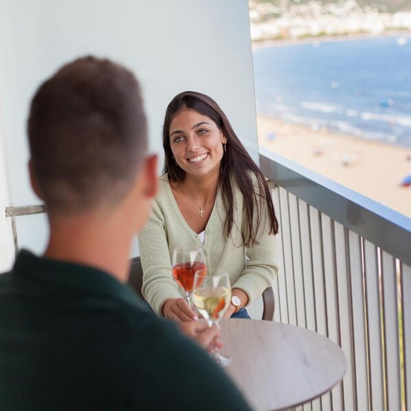 A balcony with a view of the beach and ocean.