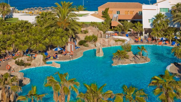 A resort with a large pool area, palm trees, and a view of the ocean. - Playavera Hotel - Naturist Friendly (Vera)