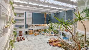 A spacious atrium with a high ceiling, multiple levels, and a central open area with seating. - Playavera Hotel - Naturist Friendly (Vera)