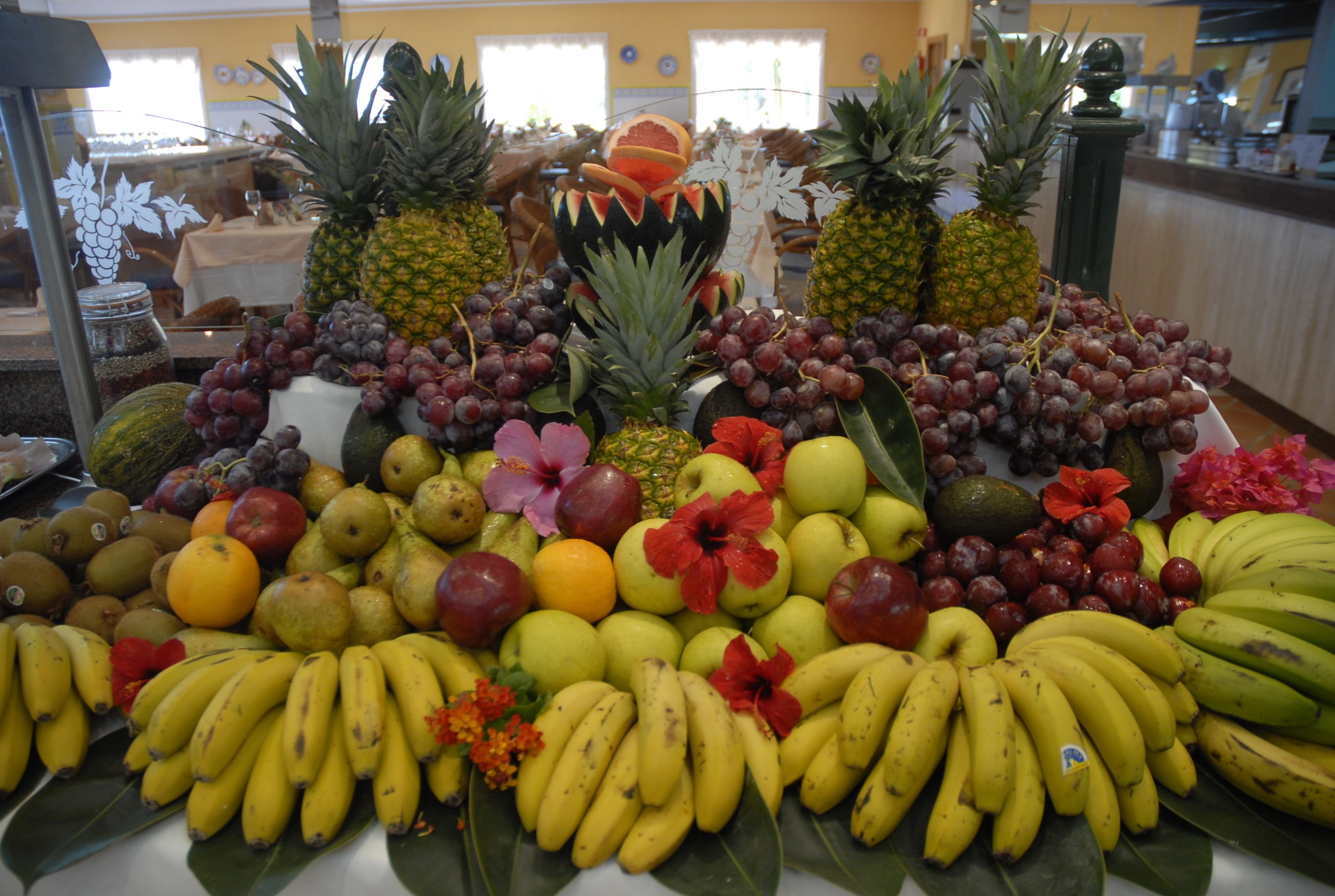 A fruit display with various types of fruits and flowers.