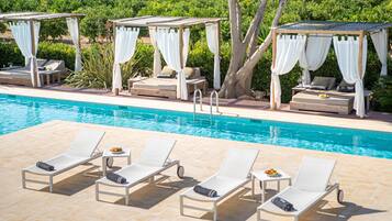 Een buitenzwembad en ligstoelen