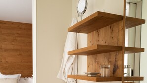 Un baño moderno con tocador de madera, un espejo grande y un lavabo blanco.