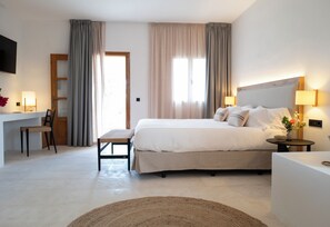 A hotel room with a bed, bedside tables, a desk, and a chair. - Can Jaume by Ocean Drive (Santa Eulalia del Rio)