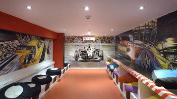 A children's play area with a race track theme, including a mural of a racing car and a track.