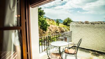 Enjoy the serene views from this balcony with a table for two and comfortable seating.