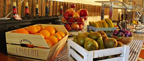 A table with various fruits and vegetables in wooden crates.