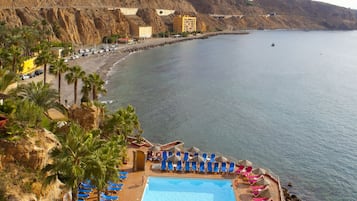 Una piscina al aire libre, sombrillas, tumbonas