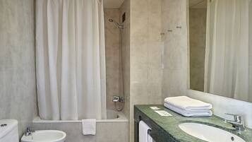 A modern bathroom with a shower, toilet, bidet, and sink.