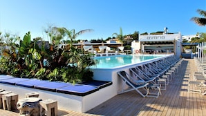 Un área junto a la piscina con sillones de descanso, una piscina y un edificio con la leyenda 'avano'.