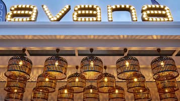 Letrero iluminado de 'Avana' y lámparas colgantes de estilo mimbre.