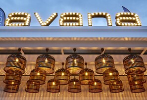 Letrero iluminado de 'Avana' y lámparas colgantes de estilo mimbre.