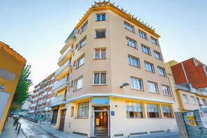 Useita kerroksia käsittävä hotelli, jonka kulmassa on sisäänkäynti, ja jossa on parvekkeita sekä selkeästi näkyvä kyltti, jossa lukee ”Hotel Santa Ana”.