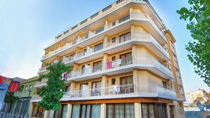 A multi-story hotel with balconies, a street view, and a clear sky. - Santa Ana (Lloret de Mar)