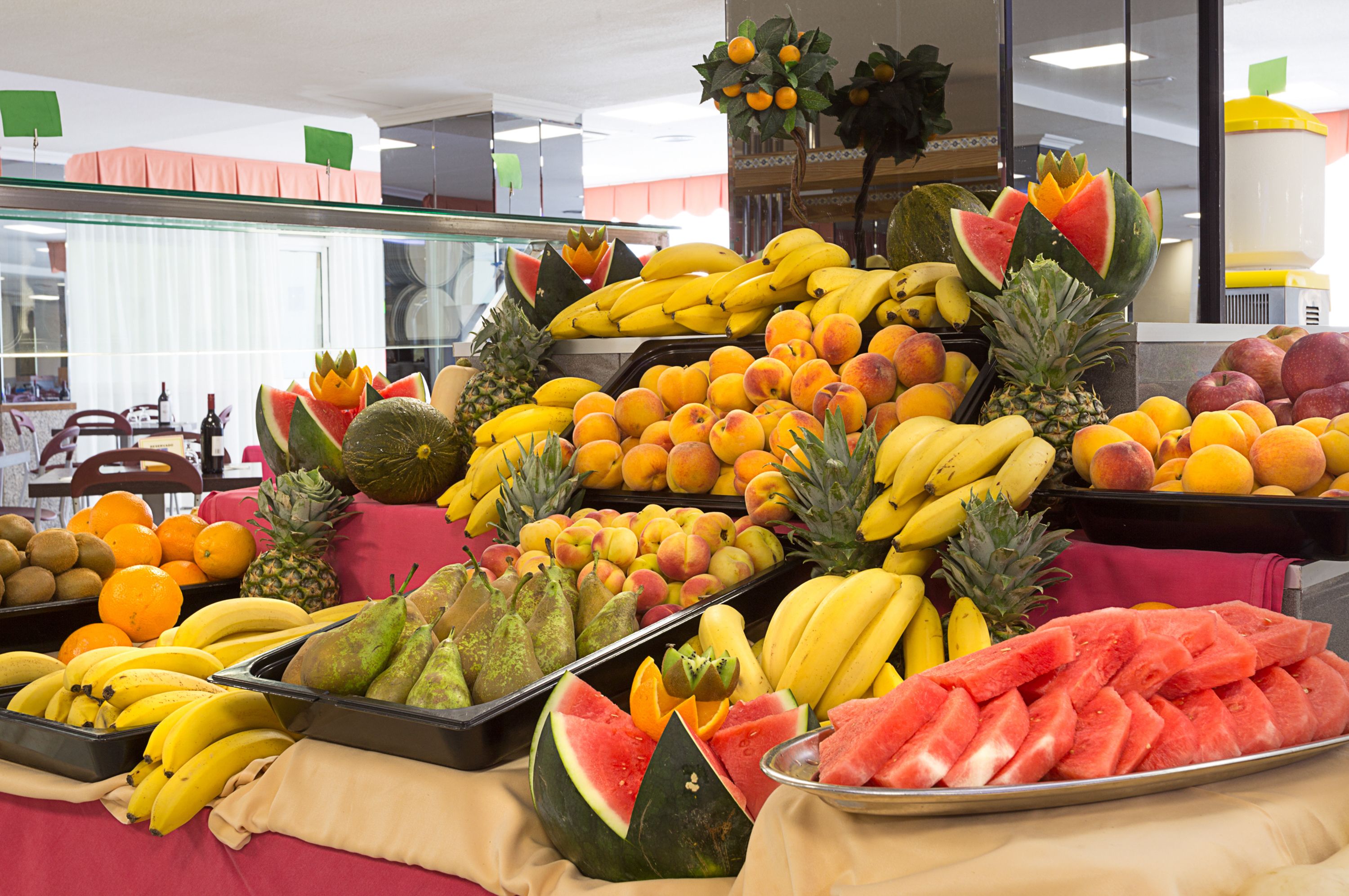 A fruit display with various types of fruits like bananas, watermelons, and pineapples.