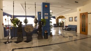A lobby with a checkered floor, blue sofas, a reception desk, and a door marked '1'.