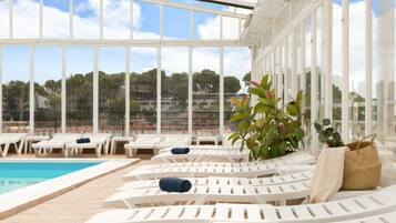 Piscina coperta, ombrelloni da piscina, lettini