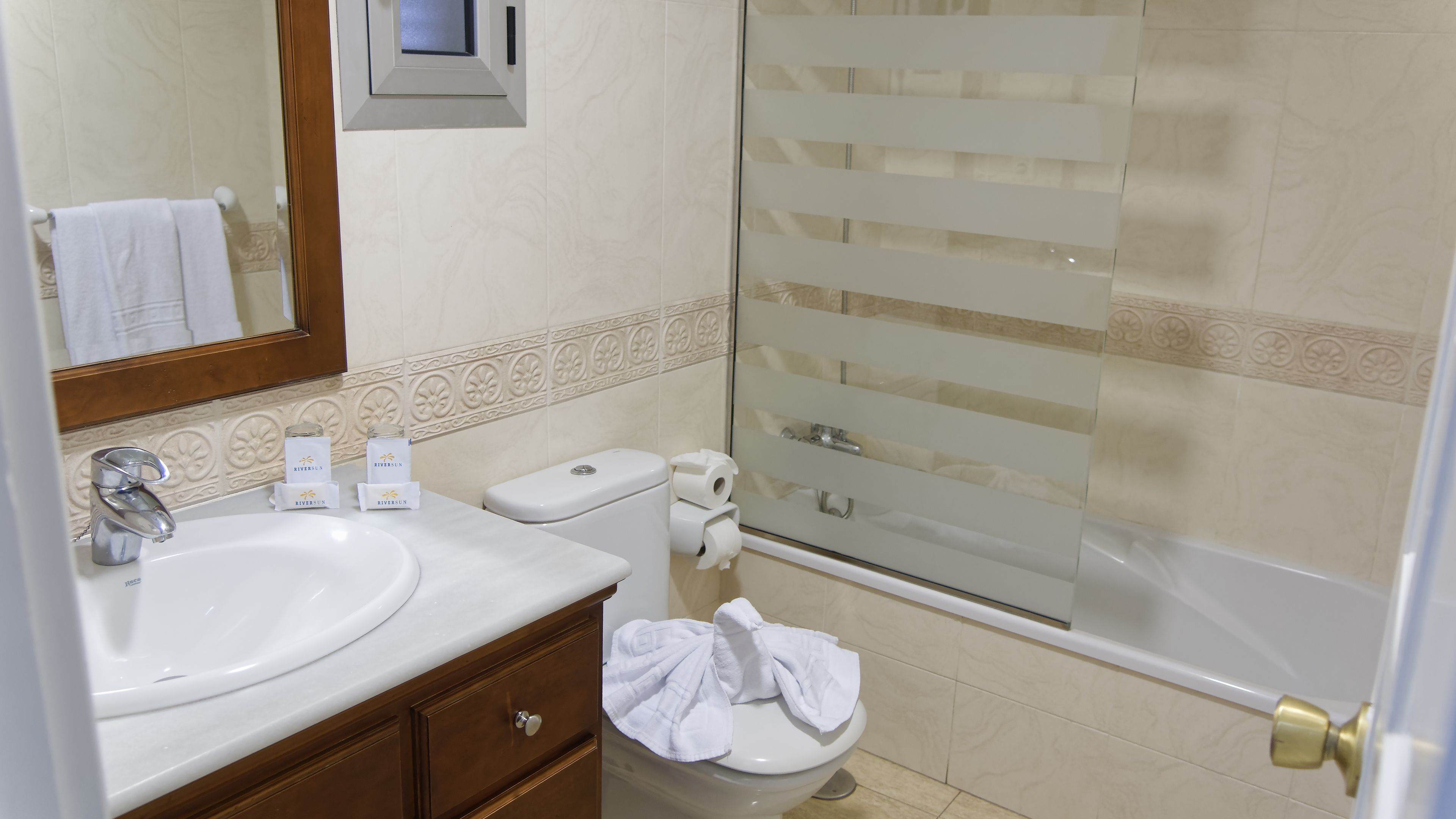 A bathroom with a sink, toilet, and shower.