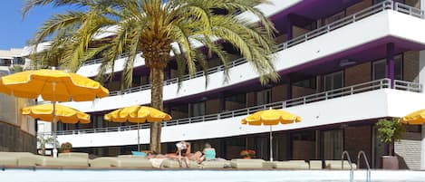 Een buitenzwembad, parasols voor strand/zwembad