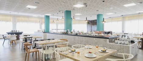 A modern dining area with white chairs, tables, and a central bar area with a marble countertop.