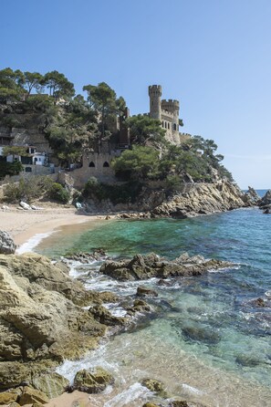 A coastal castle with a beach and rocky shoreline. - Hotel Lloret Santa Rosa by Pierre & Vacances (Lloret de Mar)
