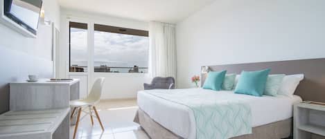Una habitación de hotel moderna con una cama grande, un escritorio y una silla.