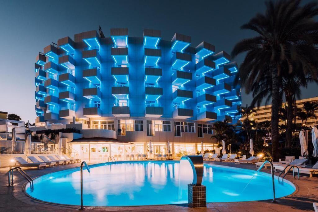 Un hotel con una arquitectura circular distintiva, piscina y zonas de descanso.