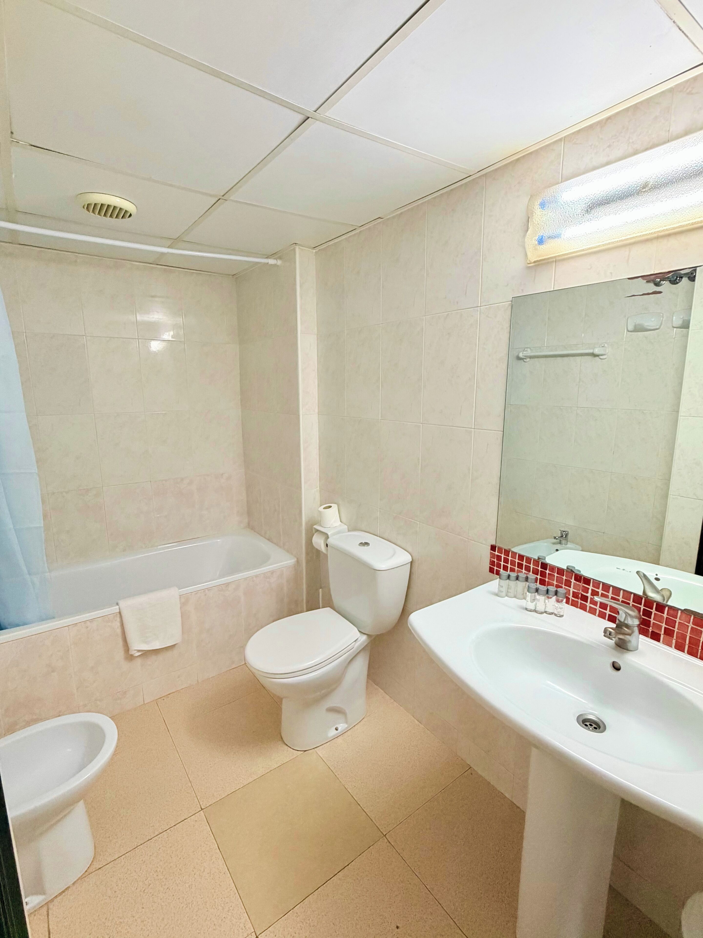 Un baño con inodoro, bidé, bañera y lavamanos.