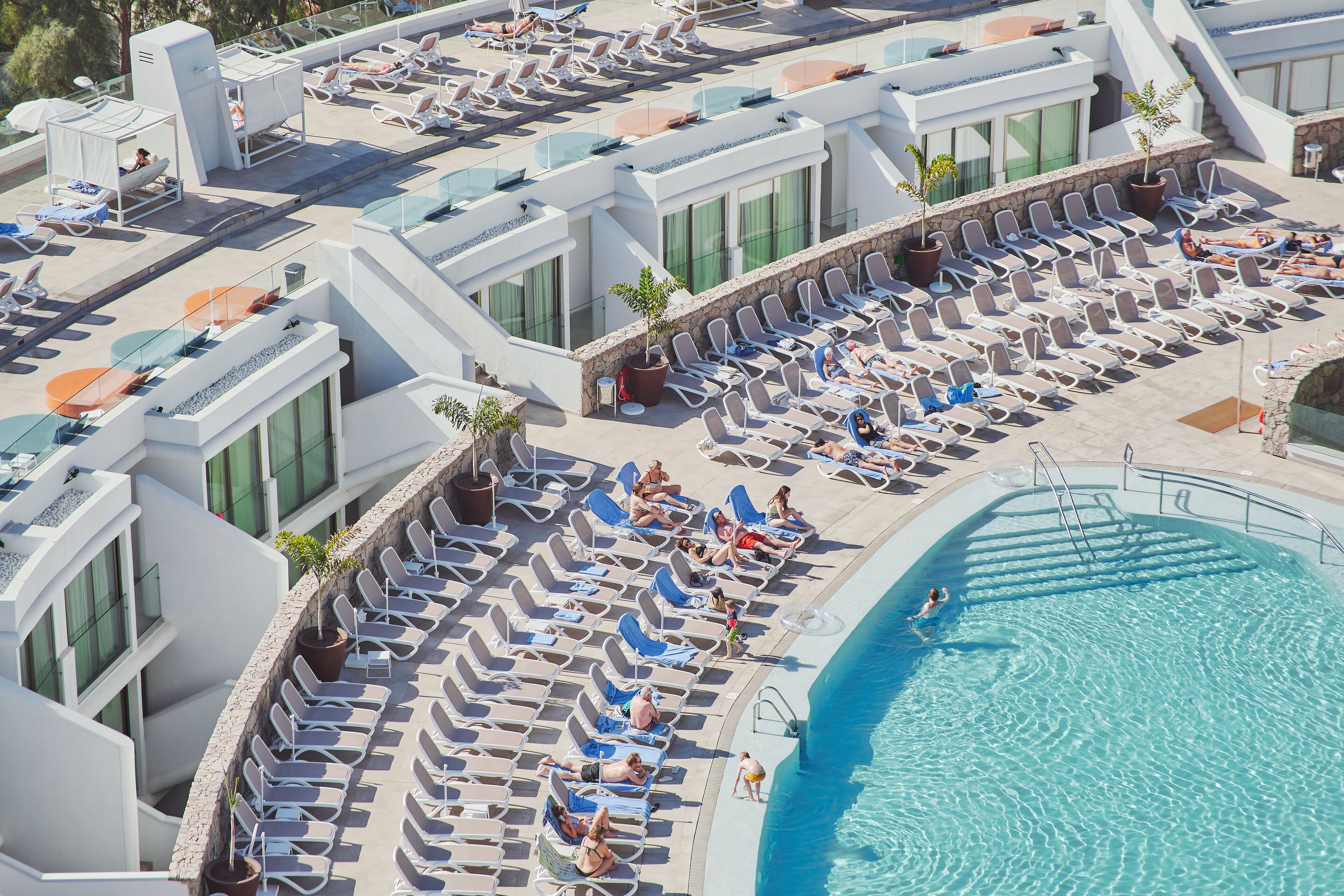 A rooftop pool area with sun loungers and a swimming pool.
