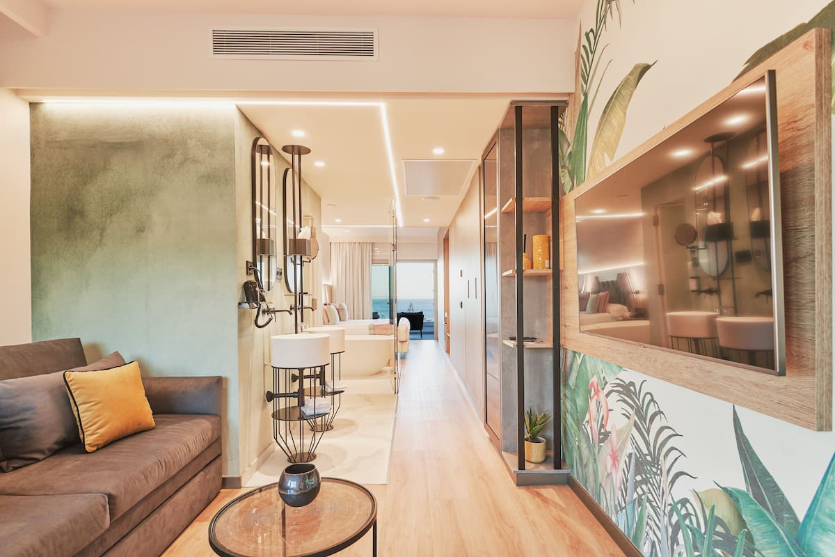 Un hall d’hôtel moderne avec un canapé, une table basse et une fresque murale.