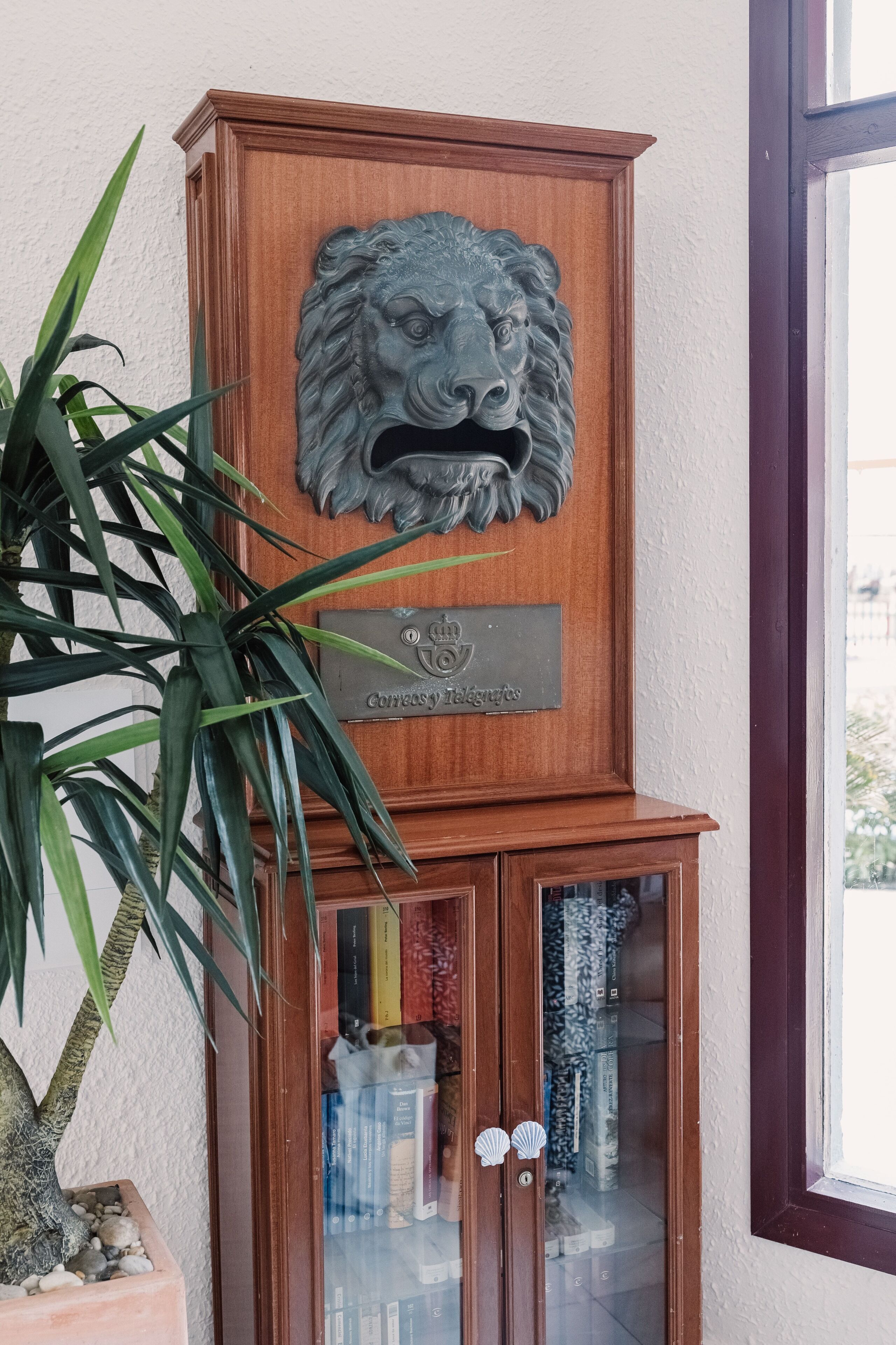 Un mueble de madera con una escultura de león y una placa.