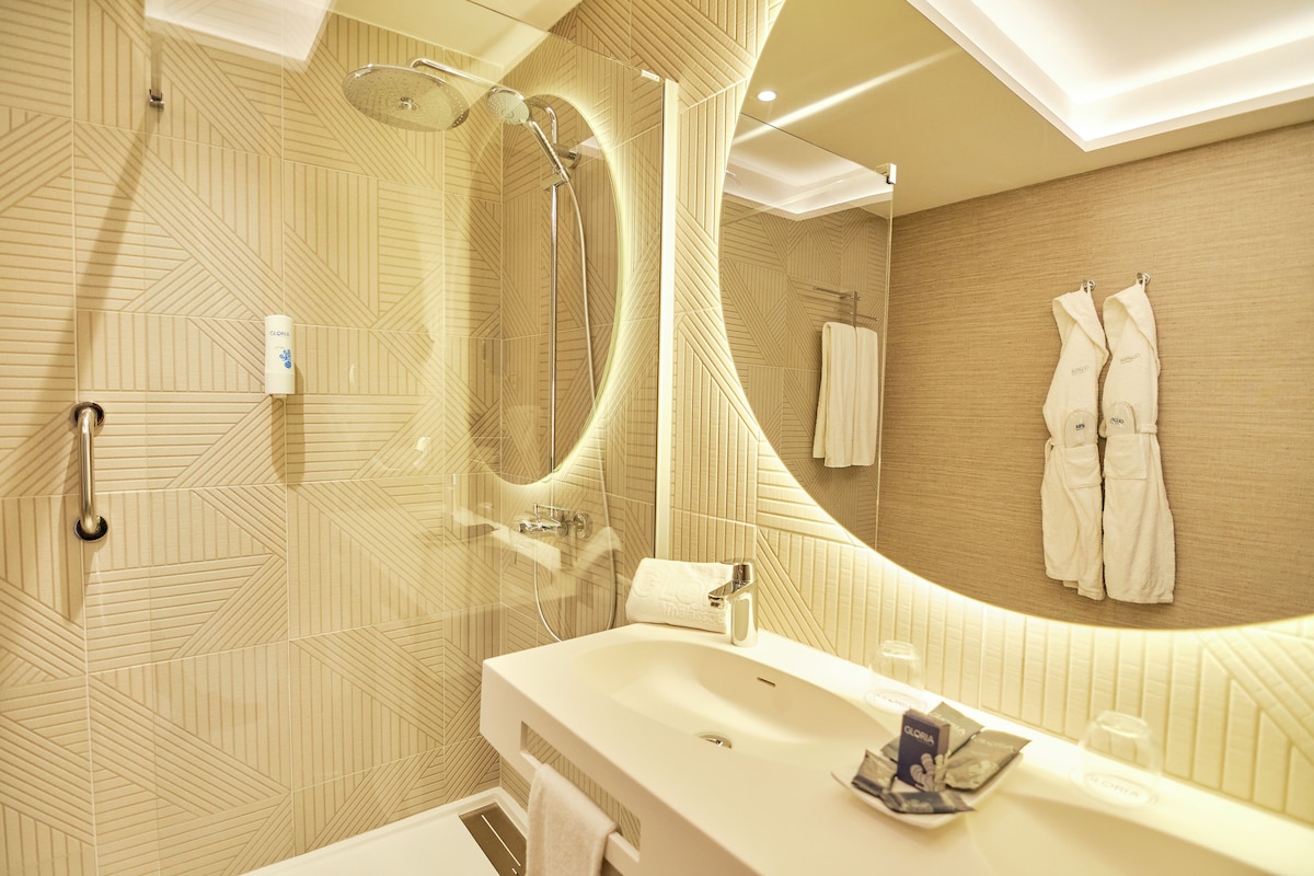 A modern bathroom with a shower, sink, and large mirror.