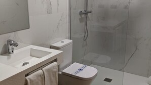 A modern bathroom with a glass-enclosed shower, a white sink, and a toilet. - Hotel Arias Aeropuerto (Castrillon)