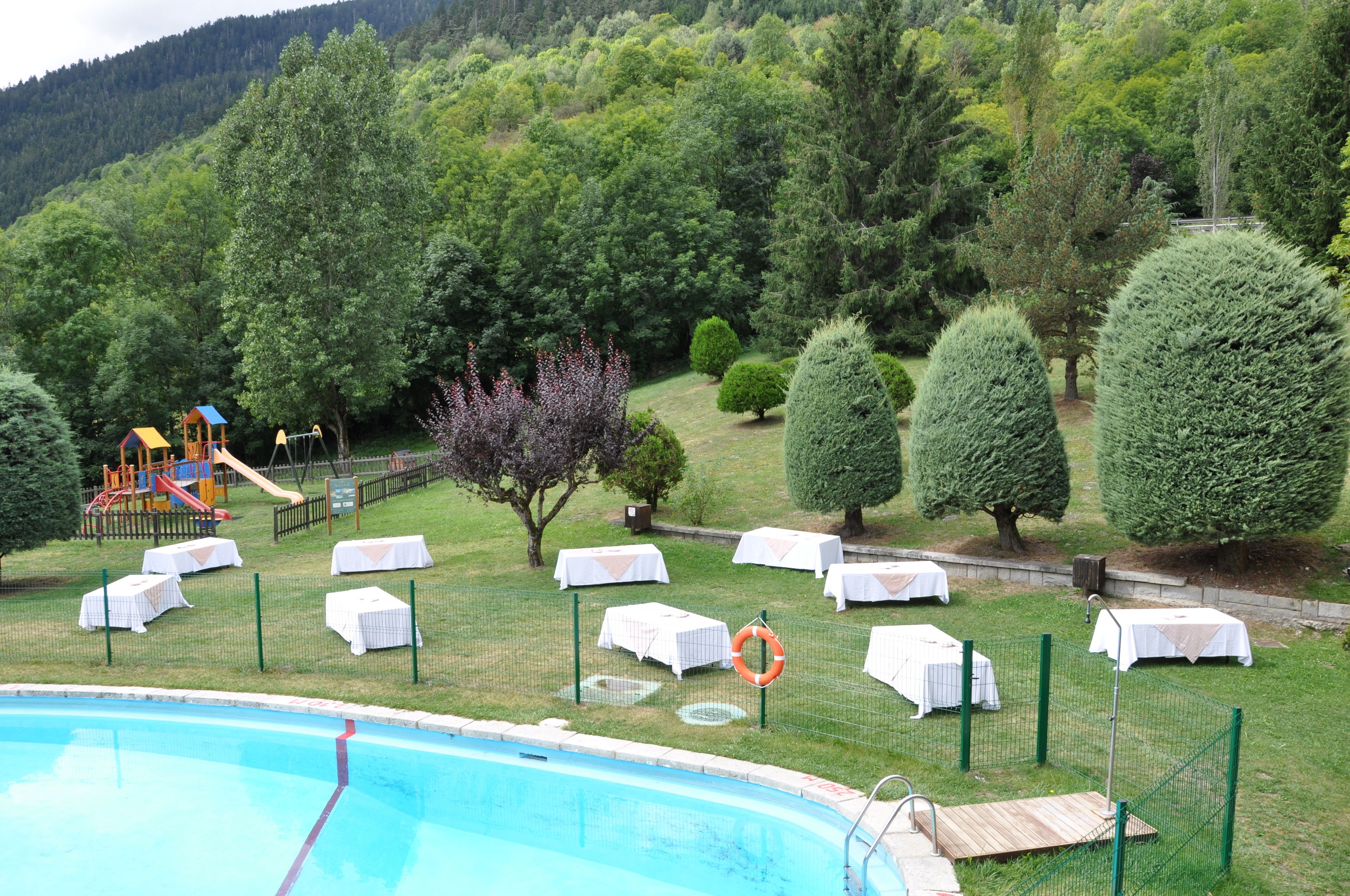 Een seizoensgebonden buitenzwembad, ligstoelen bij het zwembad