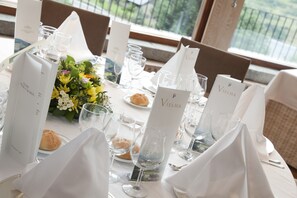 A table set for a meal with white tablecloths, glassware, and a menu stand with the name "VIELHA". - Parador De Vielha Spa & Wellness (Vielha e Mijaran)