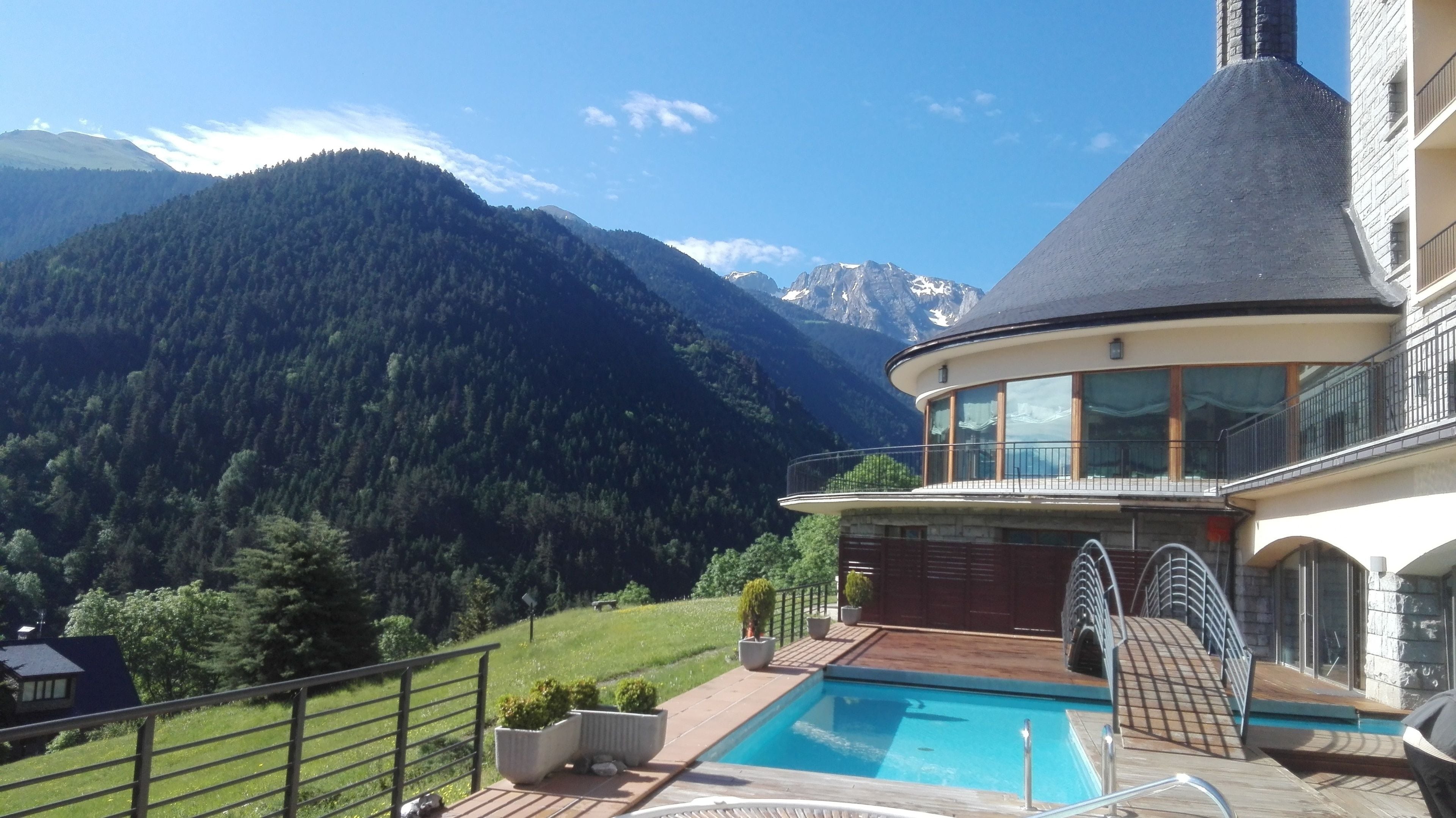 A modern house with a pool, surrounded by a mountain landscape.