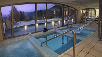 Piscina con vistas a una terraza y montañas.