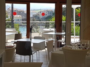 A restaurant with outdoor seating overlooking a coastal town. - Faro de San Vicente (San Vicente de la Barquera)