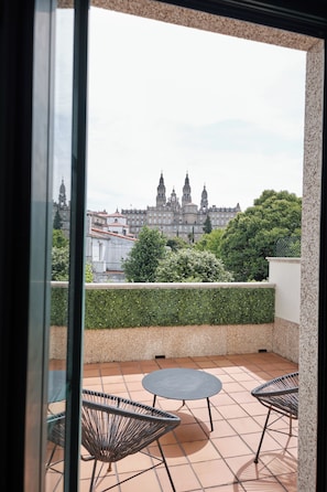 Un balcón con vista a un edificio histórico, una mesa redonda y dos sillas.