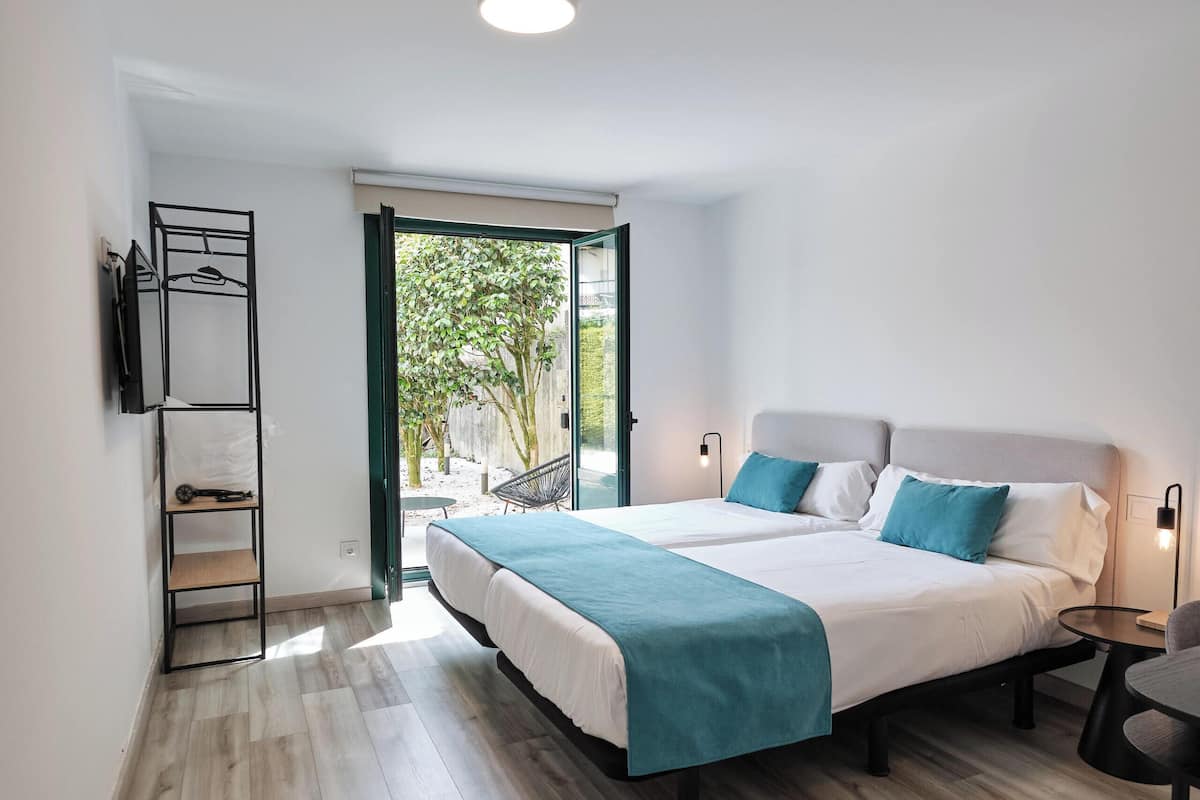 Quarto moderno com cama grande, guarda-roupa embutido e vista para o exterior.