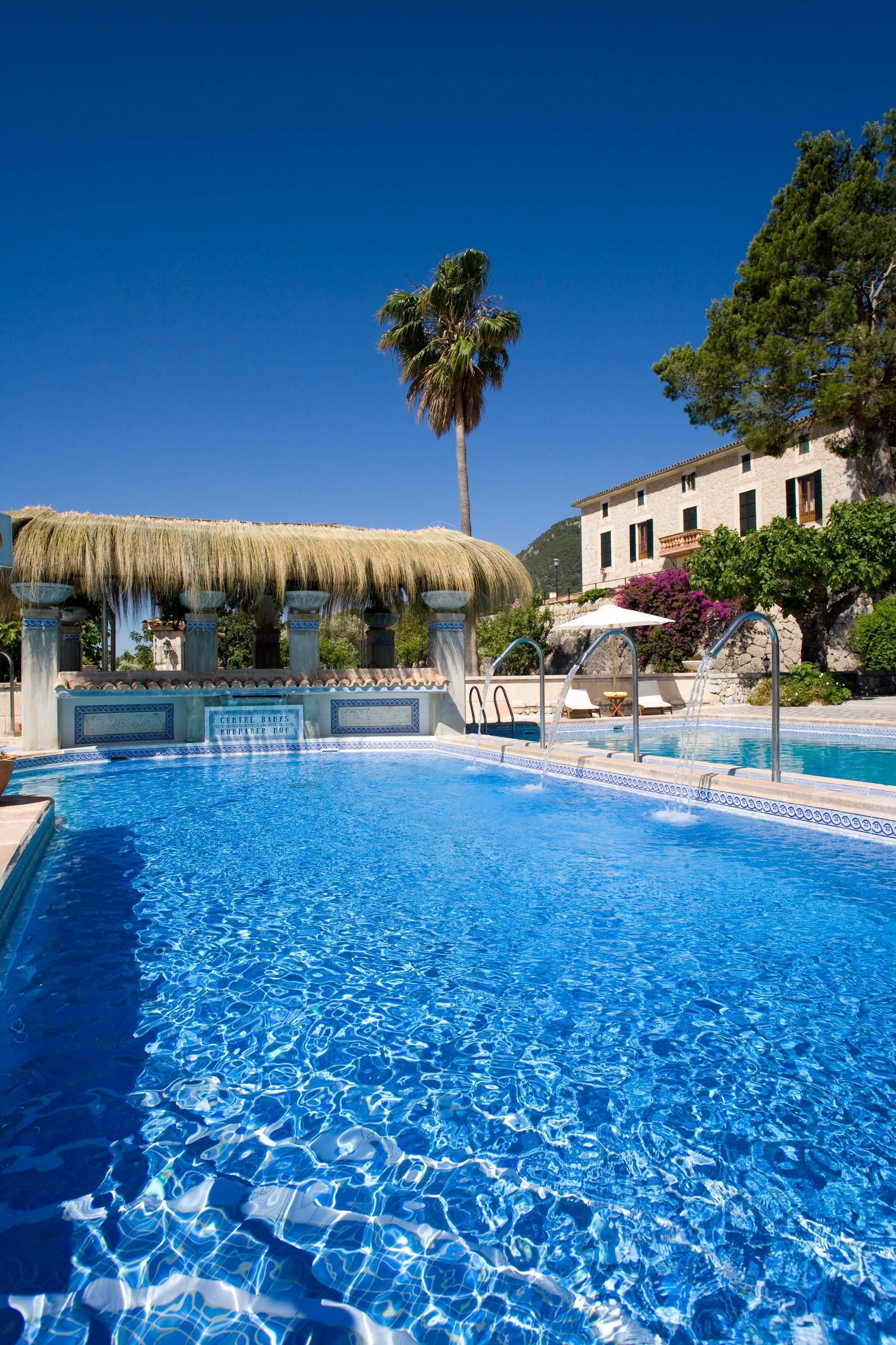 Een binnenzwembad, 3 buitenzwembaden en parasols bij het zwembad