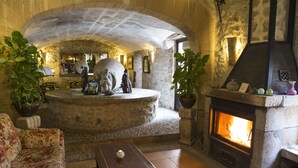 A stone-floored living room with a fireplace, a sofa, and a coffee table.