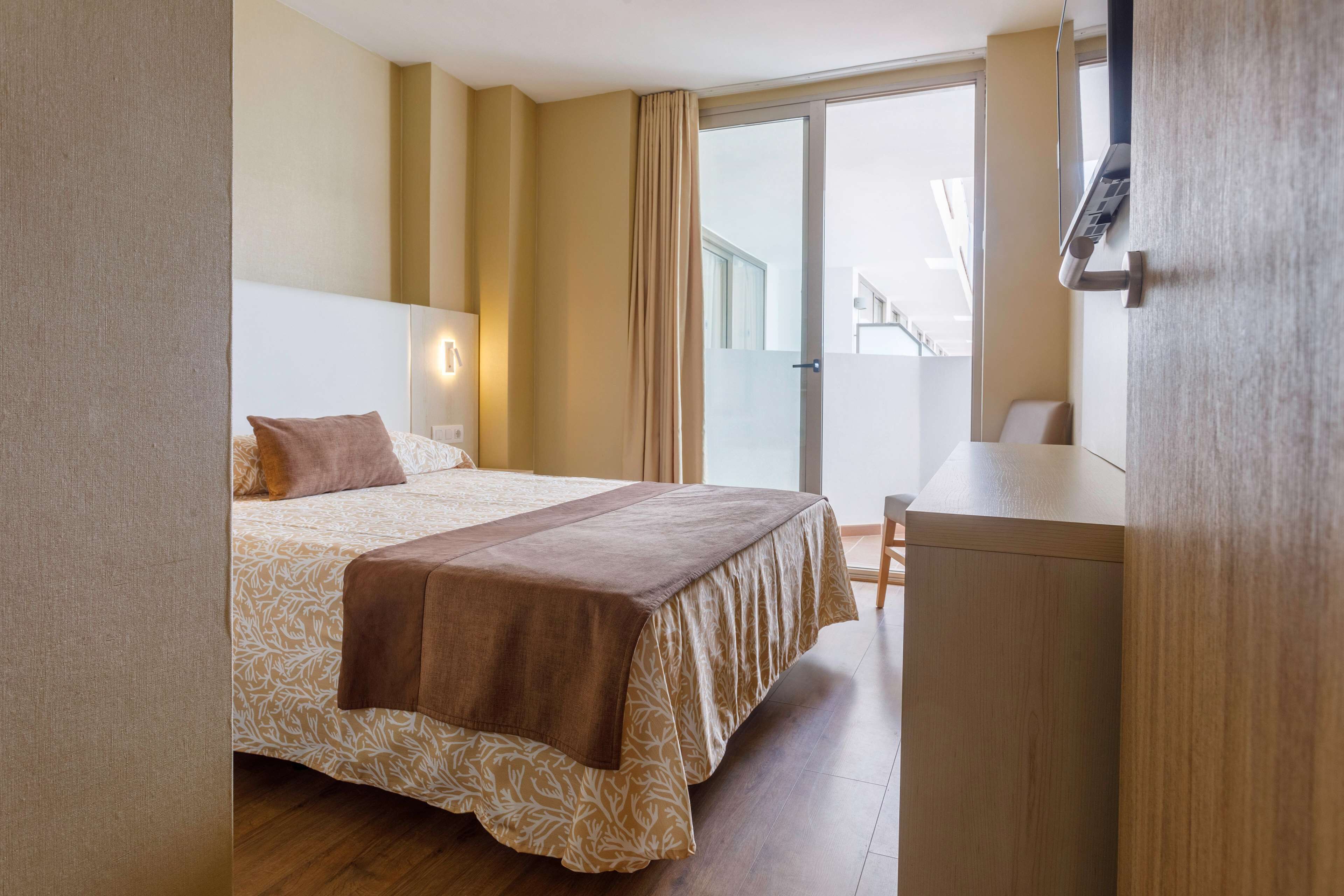 Une chambre d’hôtel avec un lit, un bureau et une vue sur l’extérieur.