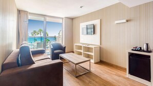 A modern hotel room with a sofa, a coffee table, a TV, and a mini-fridge. - Hotel Best Maritim (Cambrils)