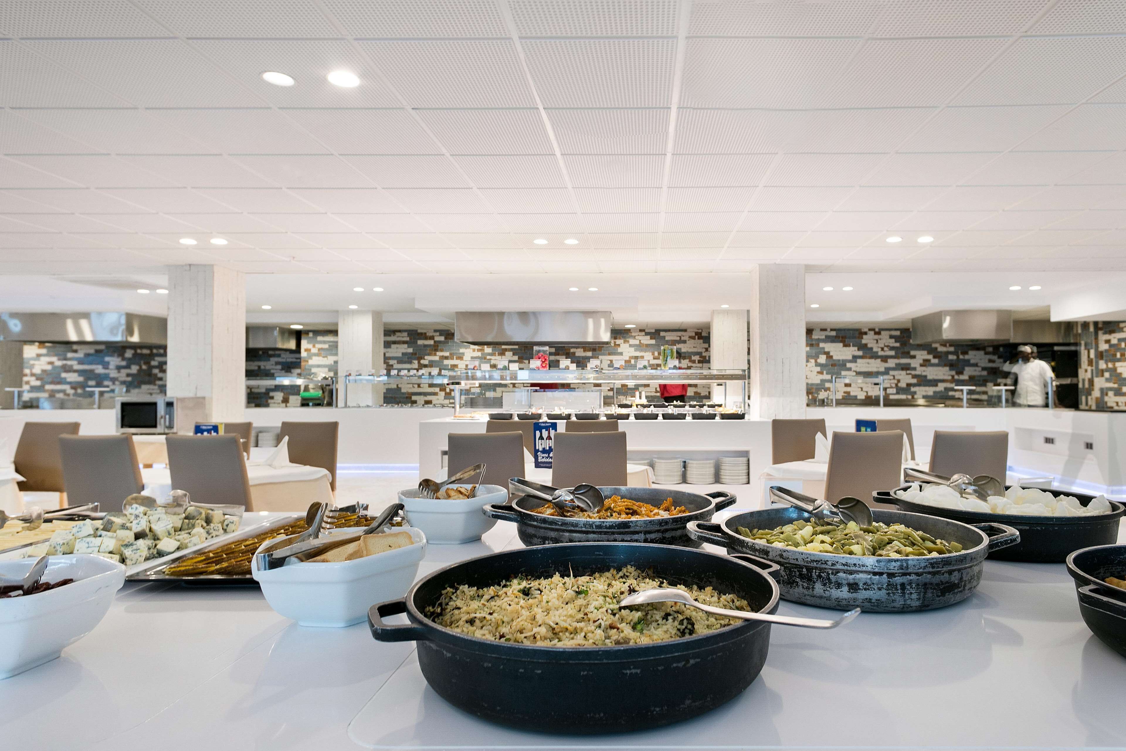 A buffet setup with various food dishes and serving utensils.