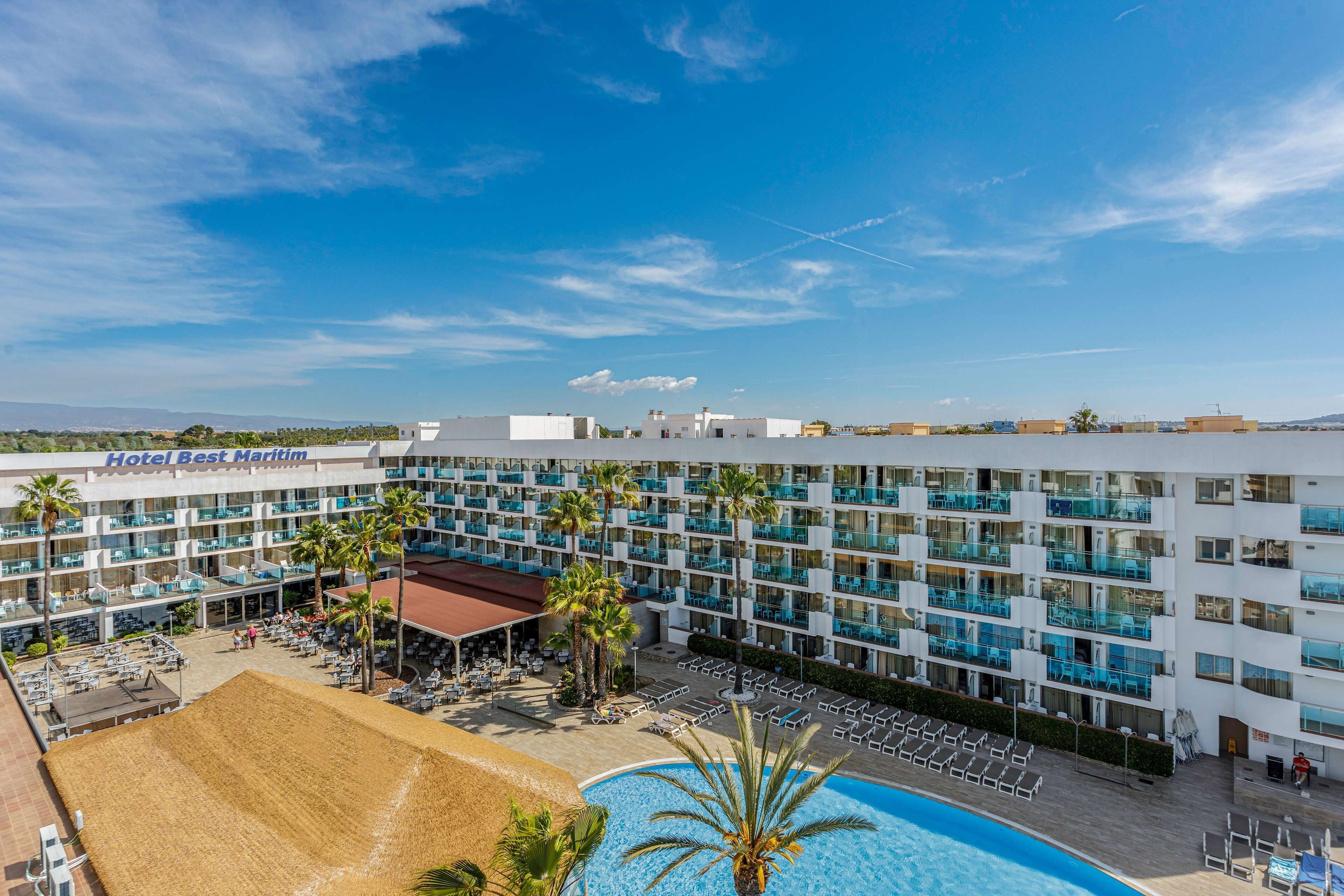 A hotel with multiple balconies, a pool area, and a beach section.