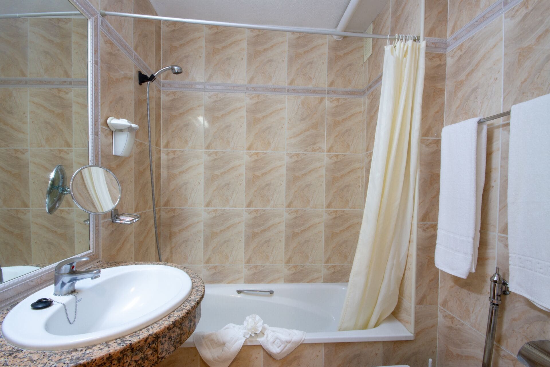 Un baño con lavamanos, espejo, ducha y bañera.