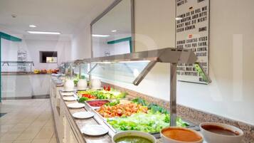 Uma área de buffet com diversas opções de comida e um letreiro com o cardápio.