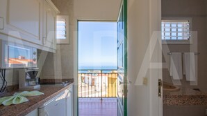 Eine Küche mit Blick ins Freie, ein Balkon und ein Badezimmer mit Waschbecken und Handtuchhalter.